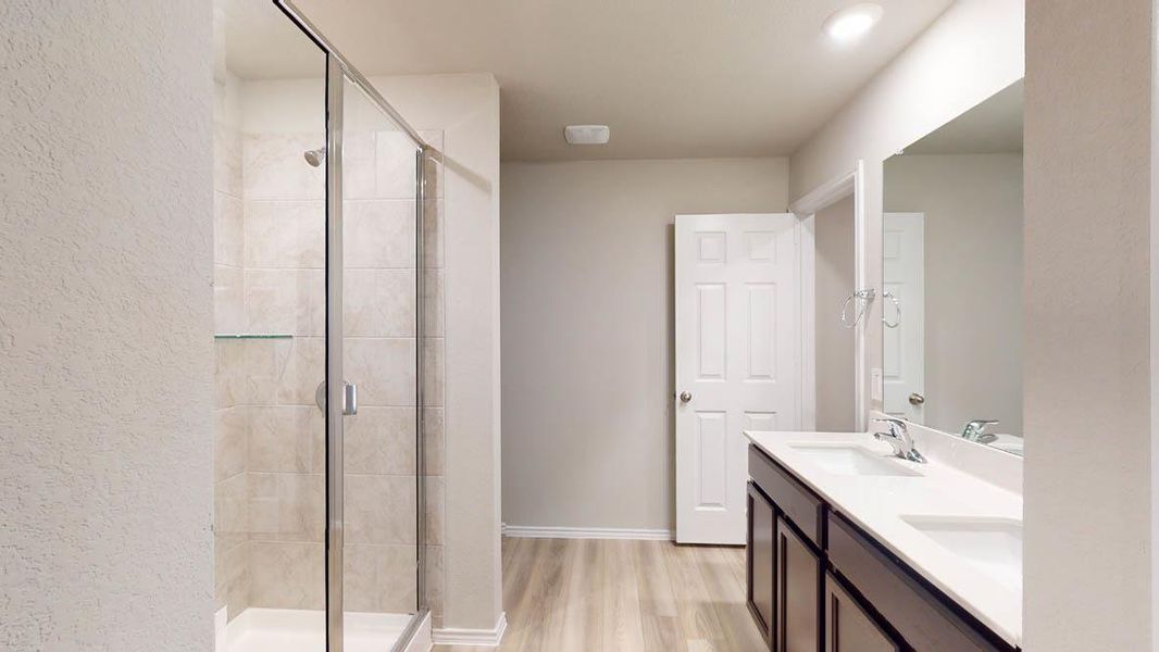 Double vanity and a tiled walk-in shower elevate daily routines in this modern bathroom. Double vanity and a tiled walk-in shower elevate daily routines in this modern bathroom.