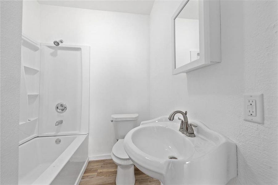 Bathroom featuring light wood-type flooring and shower / bath combination Bathroom featuring light wood-type flooring and shower / bath combination