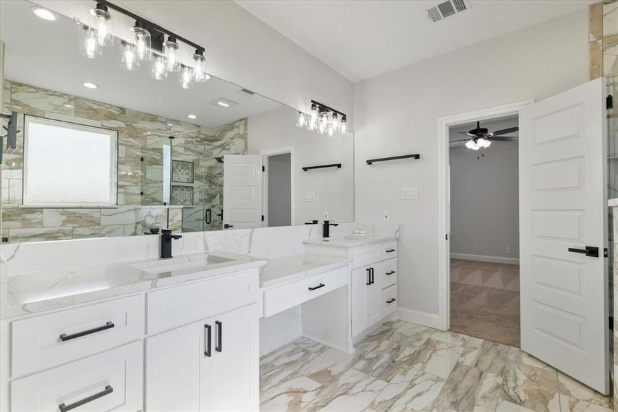 Bathroom featuring double vanity, visible vents, marble finish floor, a shower stall, and a sink