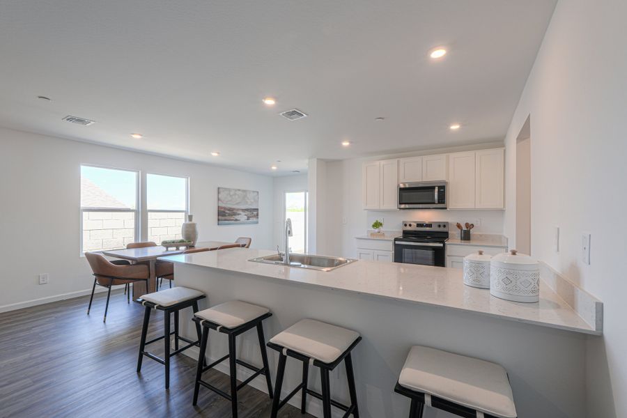 A kitchen with a bar and stools. A kitchen with a bar and stools.
