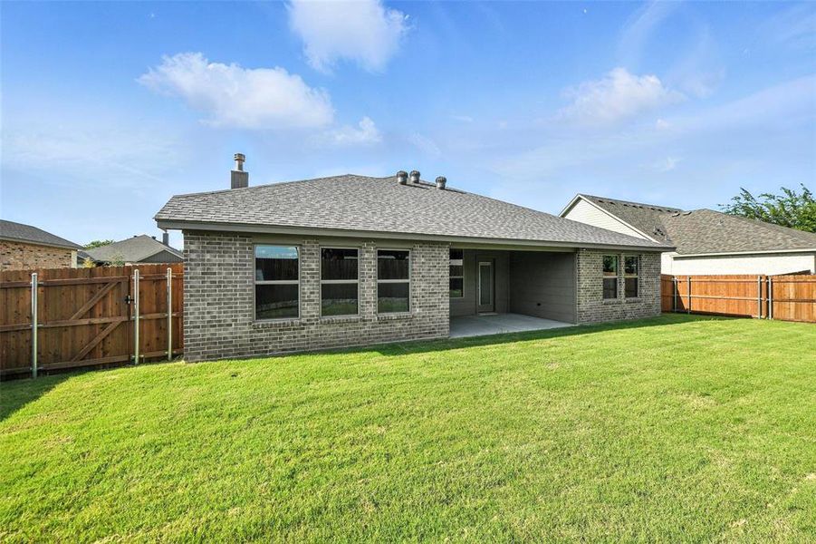 Back of house featuring brick siding, a fenced backyard, a patio, roof with shingles, and a gate
