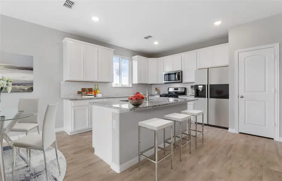 Bright kitchen with an expansive center island perfect for gatherings *Model representation