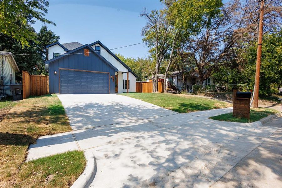 View of front of property with a front yard and a garage