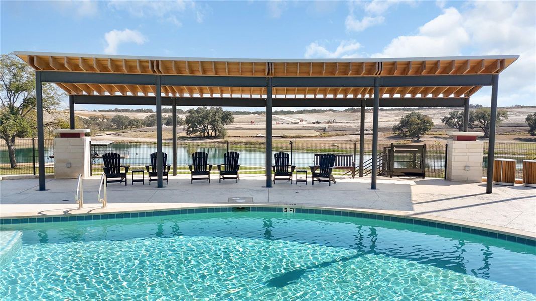 Swimming pool with a patio and a water view