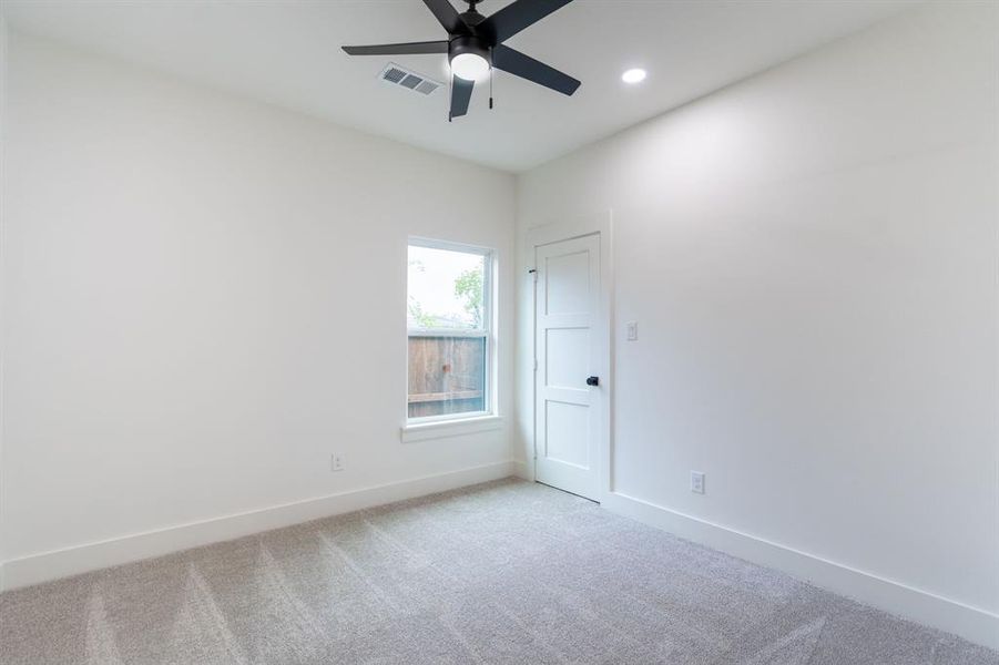 Spare room featuring light carpet and ceiling fan