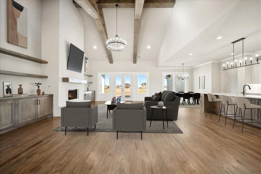 Living room featuring high vaulted ceiling, a large fireplace, a notable chandelier, beam ceiling, and hardwood / wood-style floors