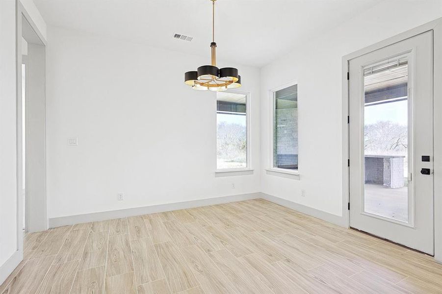 Unfurnished dining area featuring a chandelier and light wood-type flooring