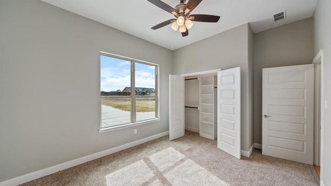 Unfurnished bedroom with light carpet, visible vents, and baseboards