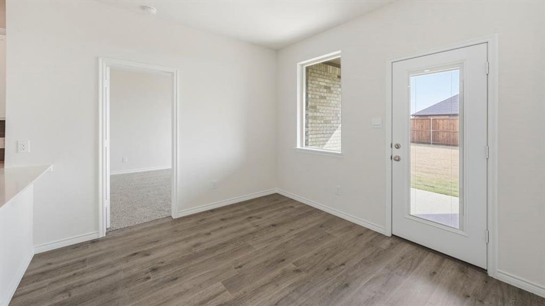 Unfurnished dining area featuring baseboards and light wood-type flooring