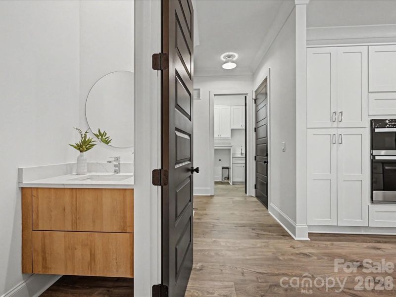 Stylish powder room featuring a modern vanity and clean finishes, conveniently located for guests.