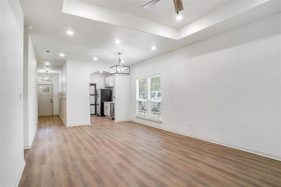 Unfurnished living room with ceiling fan and light wood-type flooring