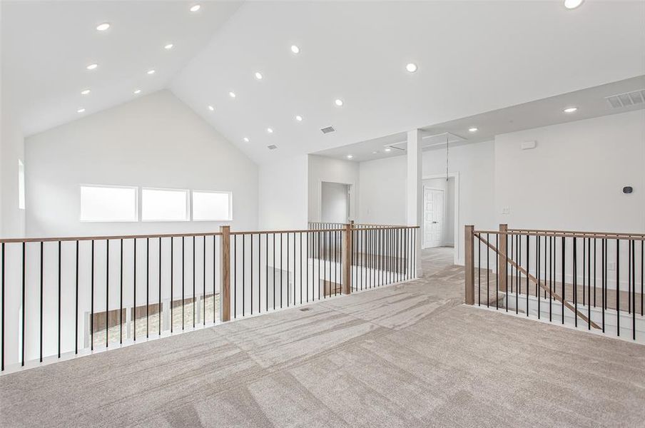 Spare room featuring high vaulted ceiling and light colored carpet