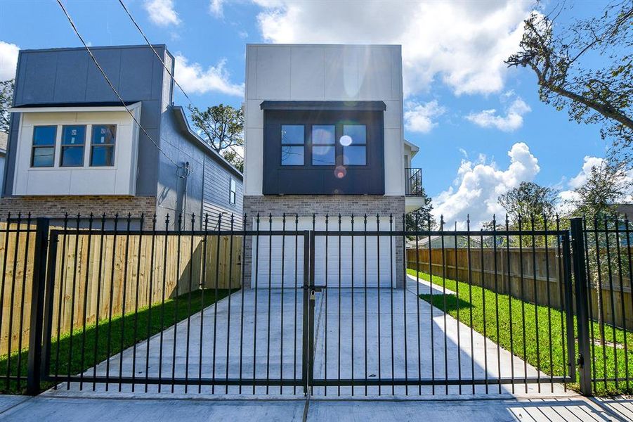 The driveway to two car attached garage has a wrought iron gate that offers ample parking space.