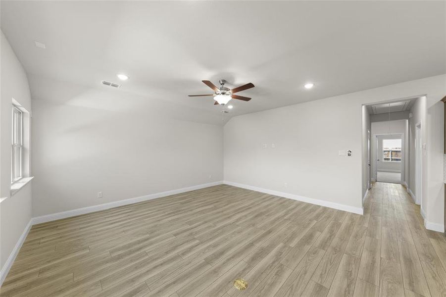 Empty room with ceiling fan and light hardwood / wood-style floors