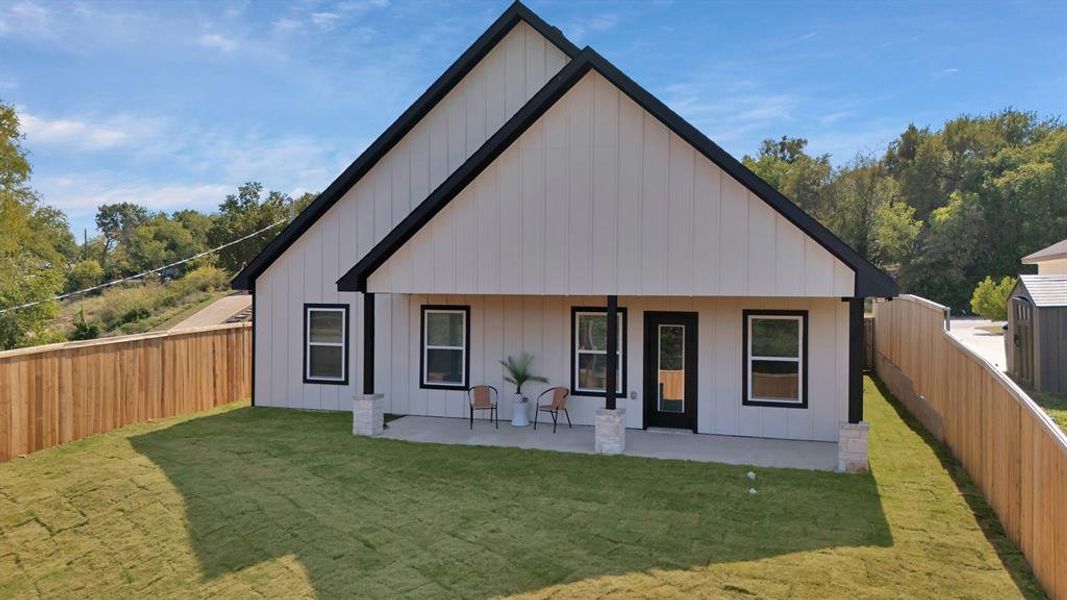 Rear view of property with board and batten siding and a fenced backyard Rear view of property with board and batten siding and a fenced backyard
