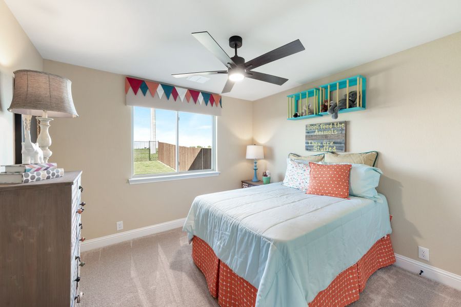 Children's bedroom with ceiling fan, full bed, carpet flooring, and a window with colorful pennant banner valance Children's bedroom with ceiling fan, full bed, carpet flooring, and a window with colorful pennant banner valance