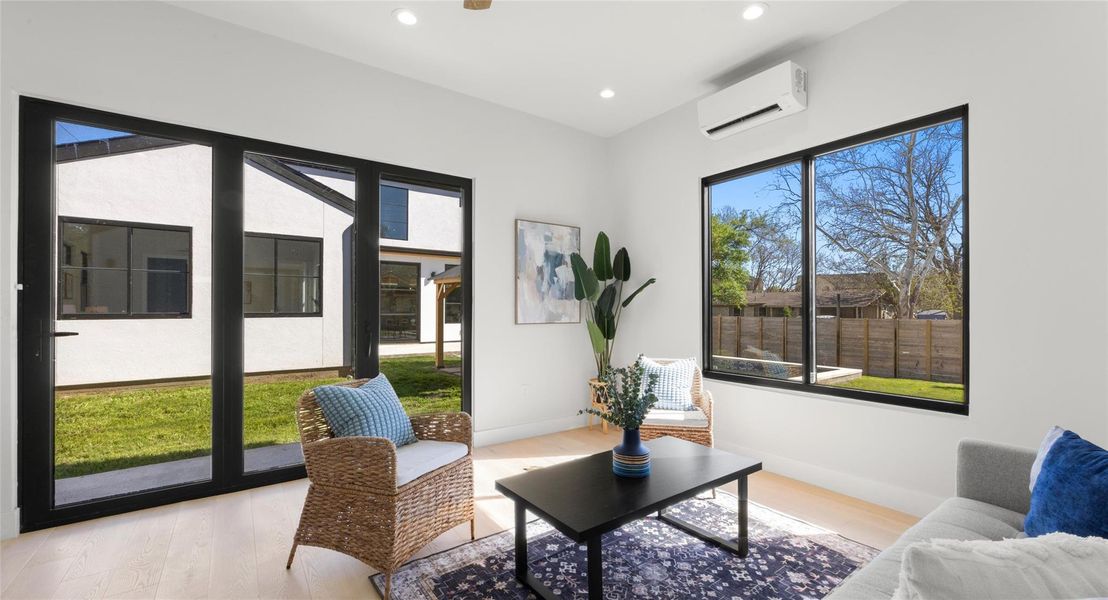 Sitting room with light wood finished floors, healthy amount of natural light, and recessed lighting
