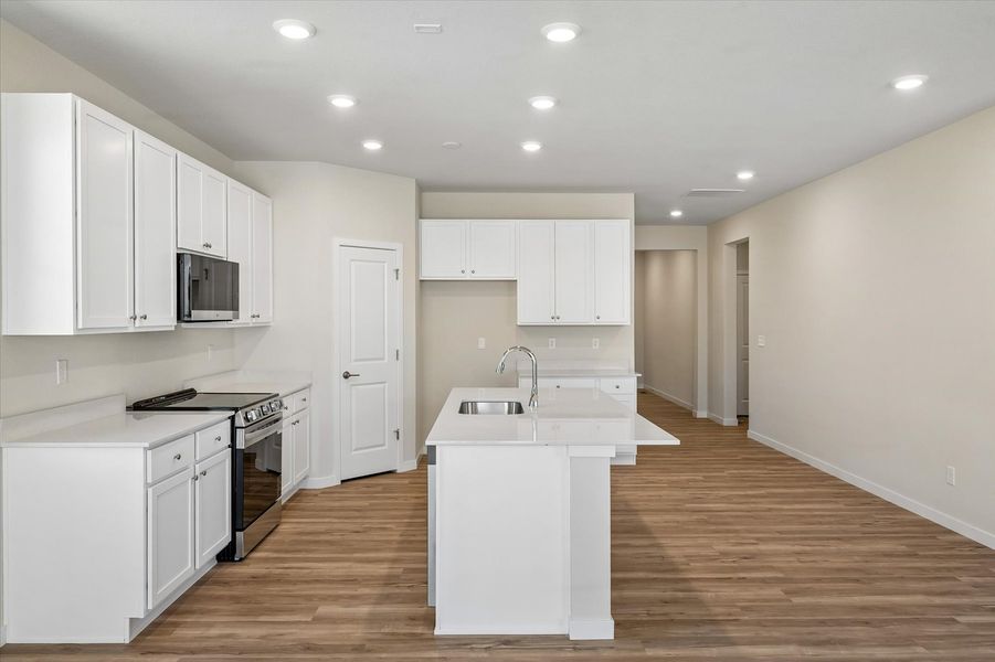 A kitchen with white cabinets.