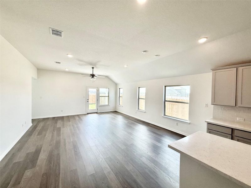 Unfurnished living room with dark wood finished floors, vaulted ceiling, recessed lighting, and ceiling fan