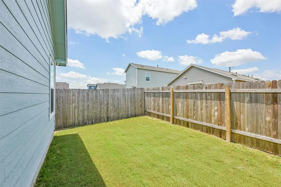 Backyard space featuring a manicured lawn and wood privacy fencing Backyard space featuring a manicured lawn and wood privacy fencing