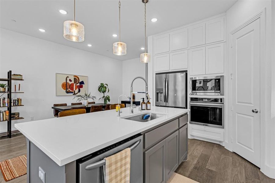 Kitchen featuring gray cabinets, dark wood finished floors, stainless steel appliances, pendant lighting, and recessed lighting