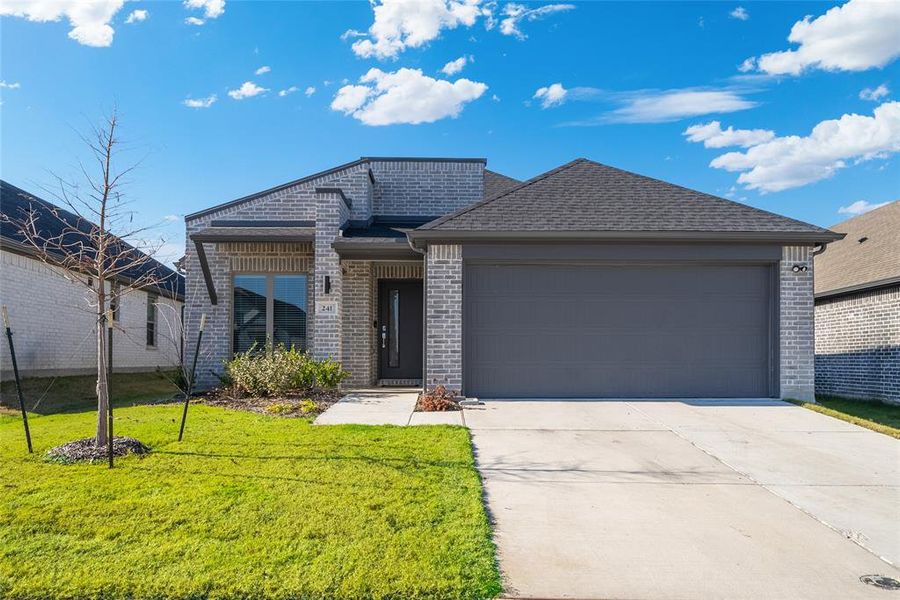 View of front of house with a garage and a front lawn