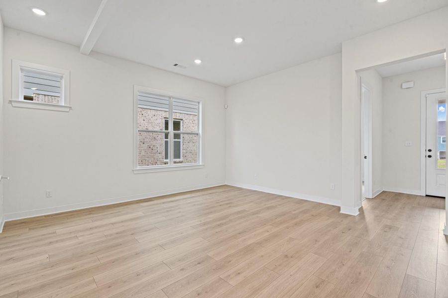 Bright open room featuring light wood-finish flooring, recessed lighting, and white trim Bright open room featuring light wood-finish flooring, recessed lighting, and white trim