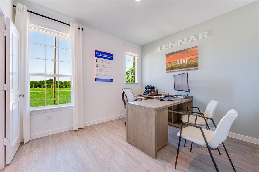 Home office featuring light hardwood / wood-style flooring and a healthy amount of sunlight