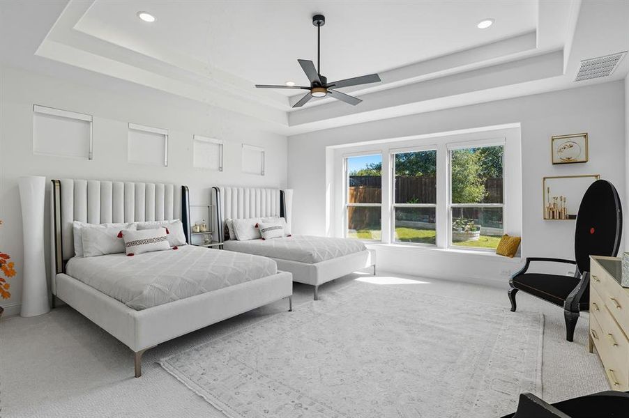 Bedroom featuring carpet floors, a tray ceiling, a ceiling fan, and recessed lighting