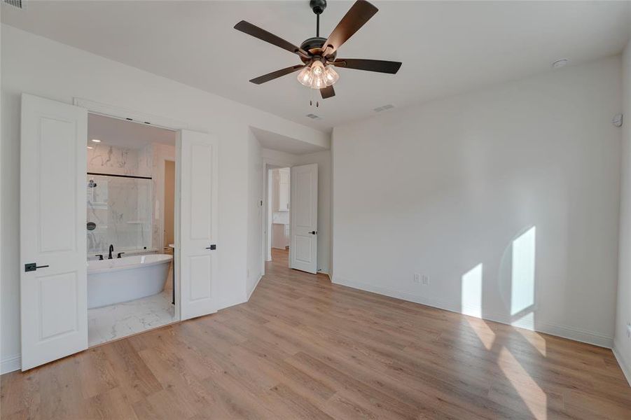 Bedroom featuring baseboards, visible vents, vinyl finished floors, and ensuite bathroom