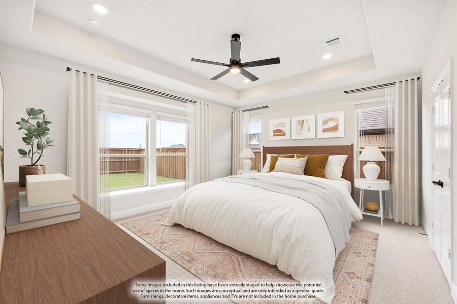 Bedroom with tray ceiling, ceiling fan, large windows, and sliding glass door to backyard