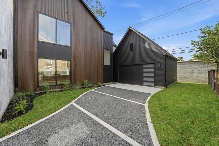 A decorative driveway with contrasting concrete bands adds visual interest and creates a polished approach to the detached garage.