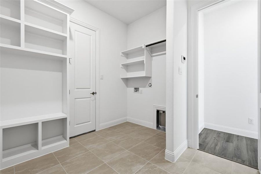 Laundry area featuring hookup for a washing machine, light tile patterned flooring, and gas dryer hookup Laundry area featuring hookup for a washing machine, light tile patterned flooring, and gas dryer hookup