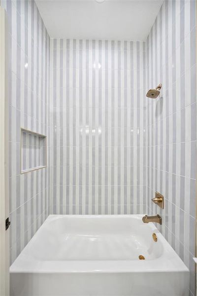 Full bath with tile walls and shower / washtub combination