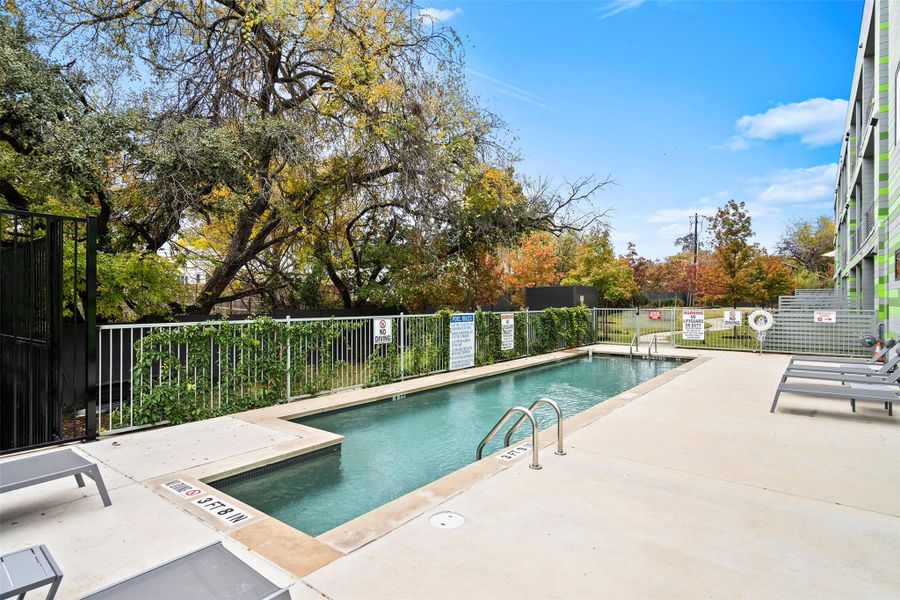 Pool with a patio area and fence