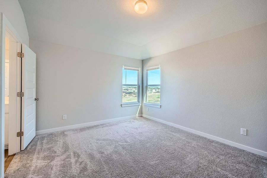 Carpeted spare room featuring baseboards