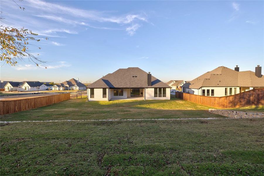 Rear view of house featuring a lawn