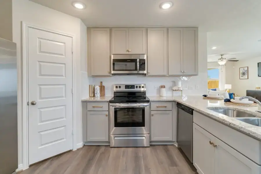 Modern kitchen with beige cabinets, stainless steel appliances, and granite countertops Modern kitchen with beige cabinets, stainless steel appliances, and granite countertops
