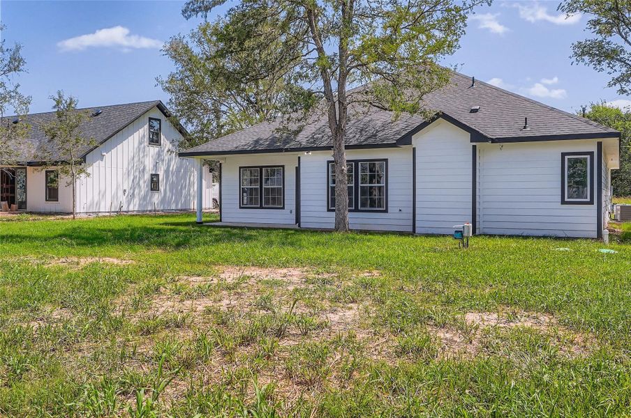 Rear view of property with a yard