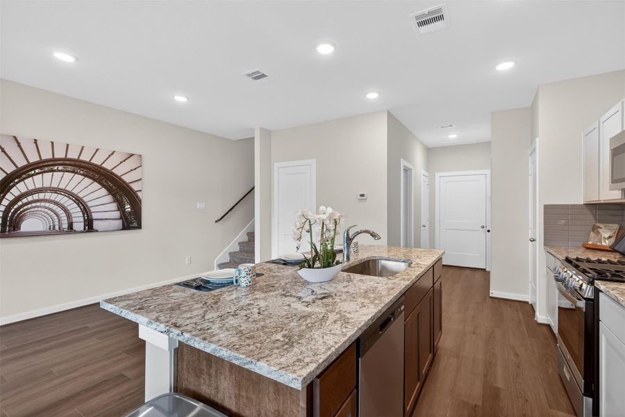 Oversized granite island with seating, an undermount sink, and ample prep space—perfect for casual dining and hosting. Oversized granite island with seating, an undermount sink, and ample prep space—perfect for casual dining and hosting.