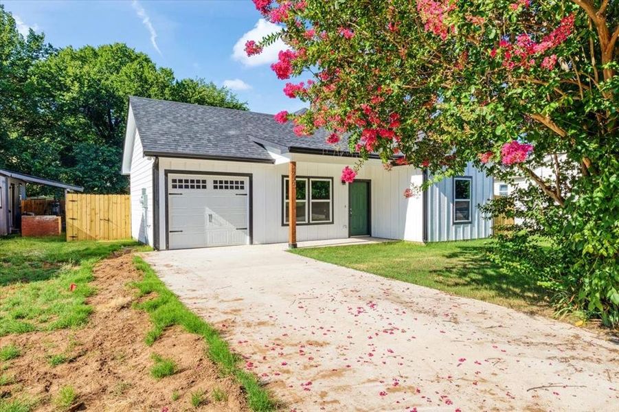 View of front of house with a garage and a front yard