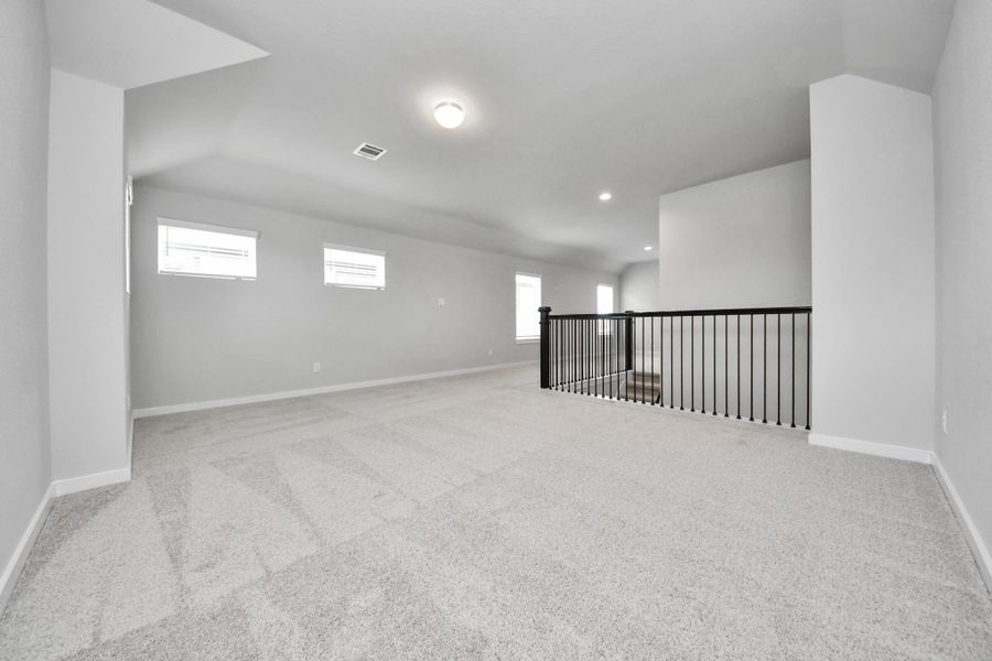 Ascend to relaxation in this fantastic game room! Ideal for both casual gatherings and adult gaming, it boasts plush carpet, lofty ceilings, custom paint, and ample windows for abundant natural light. Sample photo of completed home with similar floor plan. Actual colors and selections may vary.