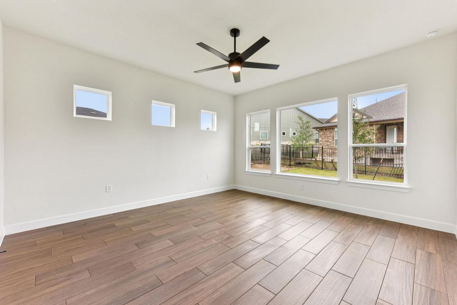 Unfurnished room with wood finish floors, healthy amount of natural light, and ceiling fan