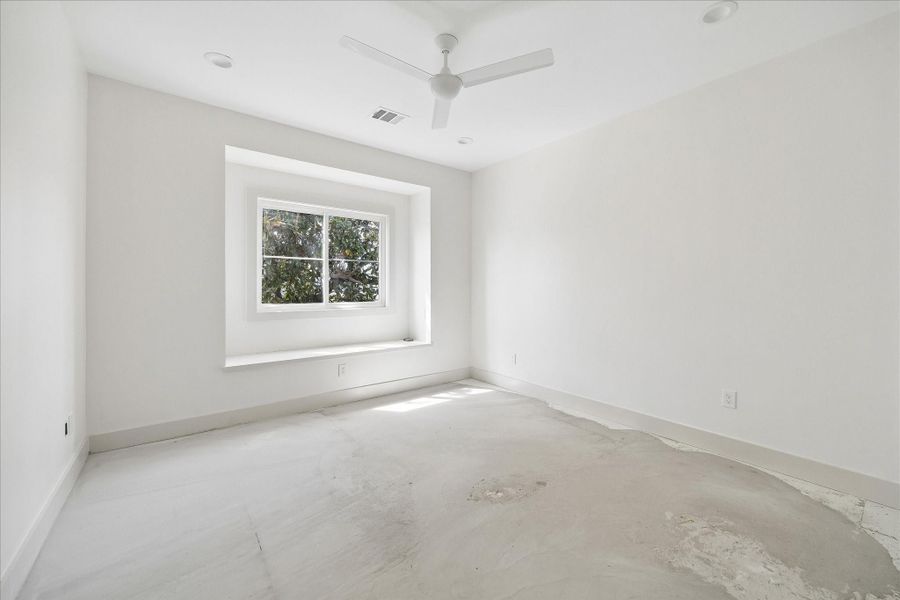 Another well appointed secondary bedroom featuring a deep set window that creates a functional ledge and adds dimension to the space. Soft natural light fills the room, highlighting the clean lines and neutral palette. Generous proportions and a flexible layout make this room ideal for guests, family, or a quiet home office.