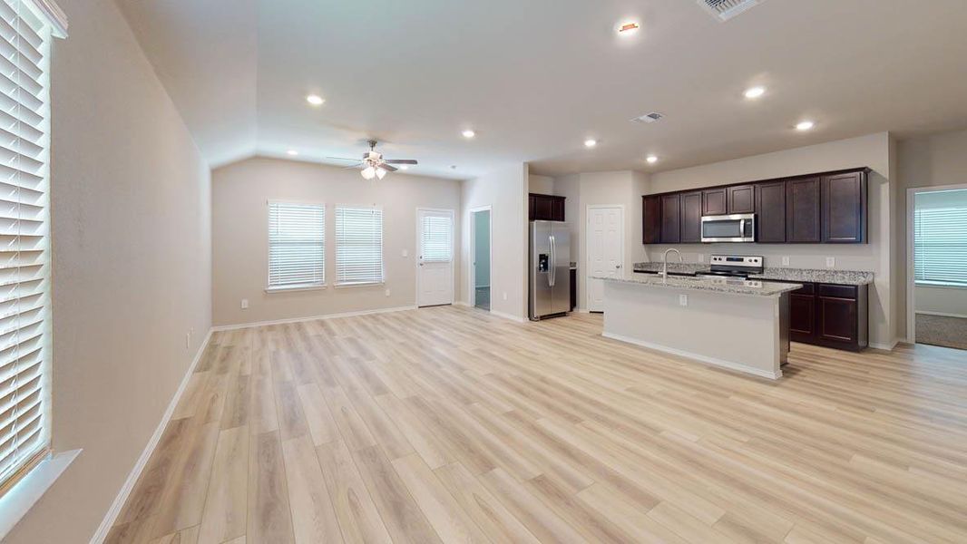 An open concept living area seamlessly connects to a contemporary kitchen with abundant cabinet space. An open concept living area seamlessly connects to a contemporary kitchen with abundant cabinet space.