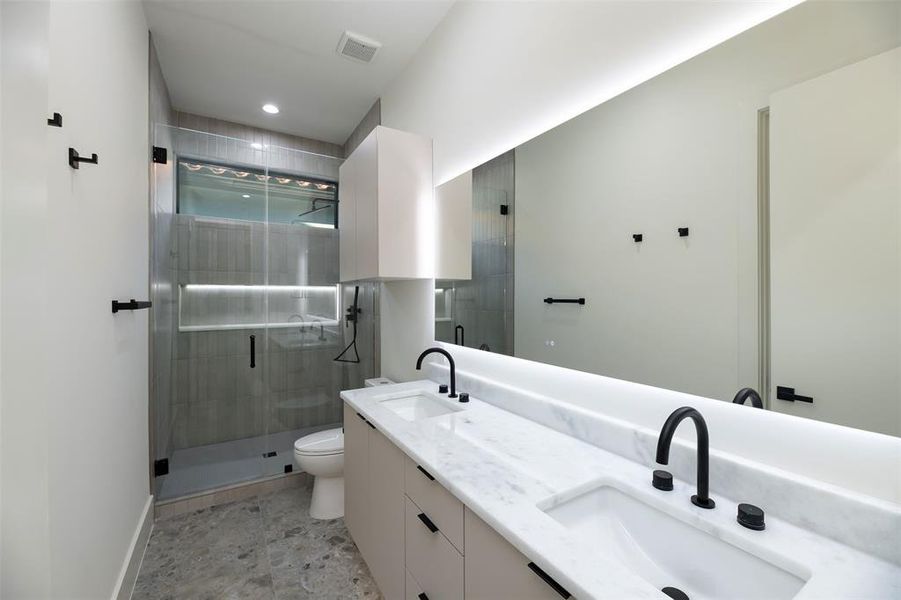 Full bathroom featuring double vanity, a shower stall, and recessed lighting