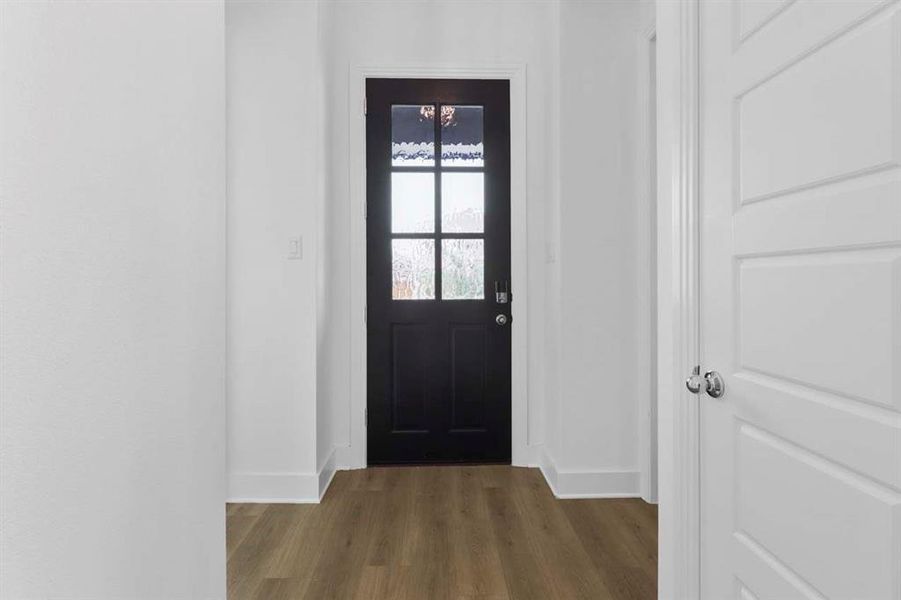 Doorway to outside with wood finished floors and baseboards Doorway to outside with wood finished floors and baseboards