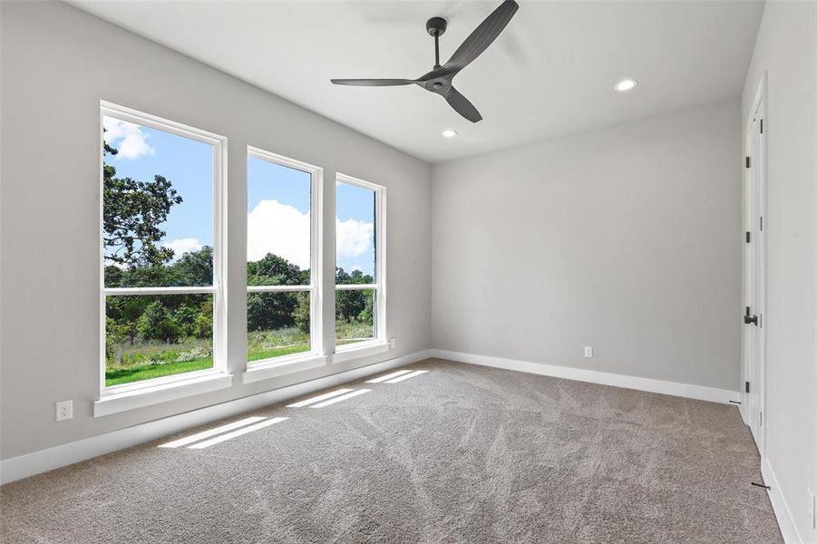 Carpeted empty room with ceiling fan