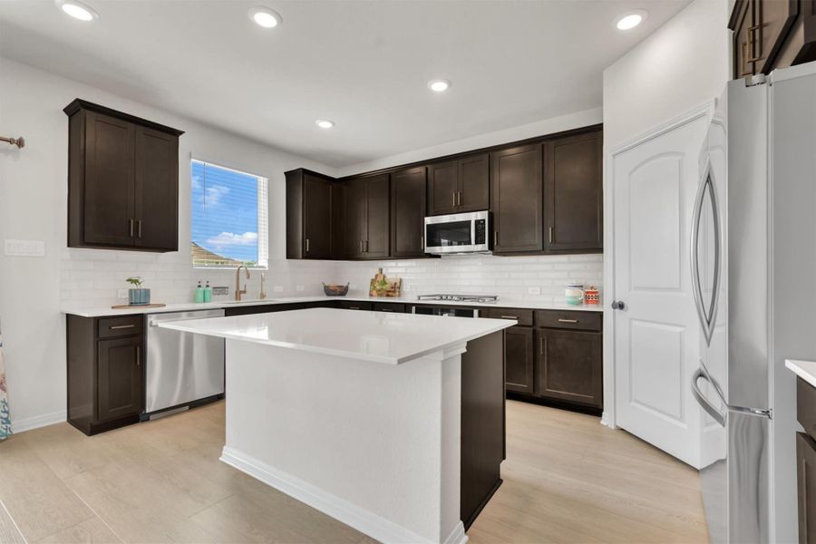 Big beautiful and bright kitchen with gorgeous quartz counters, designer backsplash, stainless cooking and gas range Big beautiful and bright kitchen with gorgeous quartz counters, designer backsplash, stainless cooking and gas range