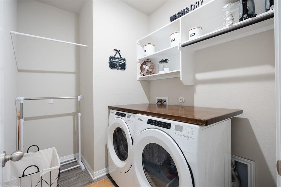 Washroom featuring washing machine and dryer and baseboards